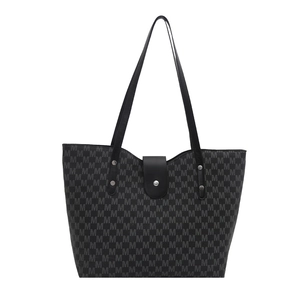Minimalist grey monogram tote bag with leather straps and metal clasp for daily commute