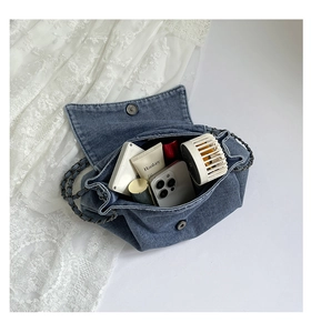 Blue denim tote interior showing spacious storage for phone and cosmetics with magnetic buckle