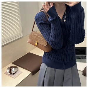 Close-up of a brown leopard print shoulder bag styled with a navy knit hoodie and skirt