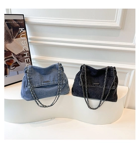 Detail view of denim shoulder bags in light blue and dark grey with woven chain straps