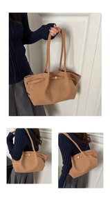 Detail of brown faux suede tote bag featuring a gold rectangular buckle and long straps