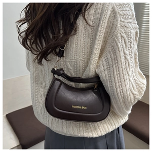 Detail of a dark brown matte leather half-moon bag featuring a knotted adjustable strap