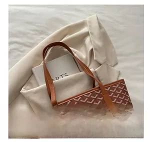 Detail of classic brown tote bag with Y-pattern print and sturdy leather handles