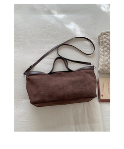 Detailed top view of a brown suede tote bag featuring contrast leather handles on beige fabric