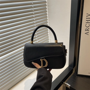 Sac selle classique en cuir noir avec boucle dorée en D et poignée élégante
