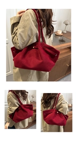 Detail view of large dark red suede tote bag with shoulder strap on beige trench coat