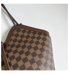 Dettaglio della borsa tote retrò a scacchi con stampe floreali e cuciture in pelle