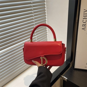 Sac à main rouge semi-ovale élégant avec pendentif D doré et poignée courbée chic