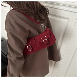 Red suede underarm bag featuring double pockets and large silver buckles worn by model
