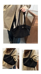 Detail of black large capacity tote bag with metal buckle strap and matte suede texture