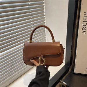 Sac à main en cuir marron avec pendentif D doré sur rabat asymétrique en décor élégant