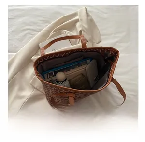 Interior view of brown tote bag showing large capacity with daily essentials and Y-pattern