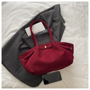 Dettaglio della borsa tote in pelle scamosciata bordeaux con fiocco e fibbia in metallo oro
