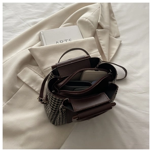 Detail of houndstooth patchwork handbag showing multi-compartment interior for phone