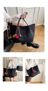 Detail of black tote bag with dual-color pompom charms and inner pouch accessory