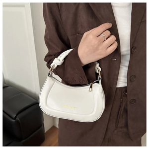 Close-up of a white half-moon bag with a knotted handle and fashion text detail