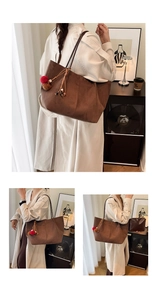 Detail of dark brown frosted tote bag with decorative pompom charms and inner pouch