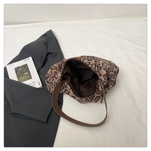 Détail du sac cabas vintage léopard avec bandoulière en cuir brun et texture toile