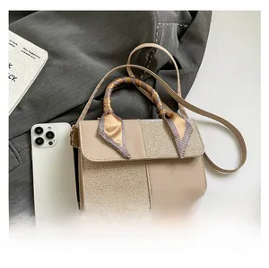 Detail of beige PU leather crossbody bag with silk scarf handle and phone for size reference