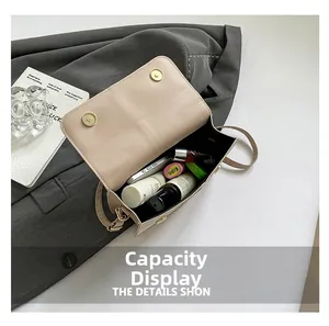 Detail view of the spacious inner compartment of the cream crossbody bag with daily items