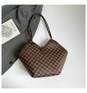Vista dettagliata di una borsa tote a scacchi marrone con blazer grigio e decorazioni