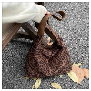 Détail d'un sac cabas léopard tendance avec poignées en cuir marron sur le sol