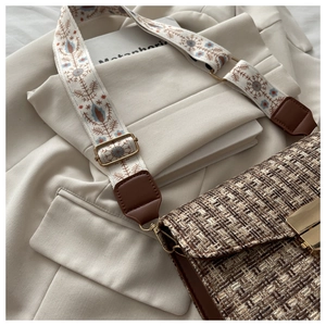 Détail du sac bandoulière en tweed tissé avec large sangle brodée de motifs floraux fins