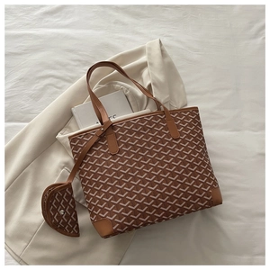 Detailed view of brown monogram tote bag set with matching zipper pouch on beige blazer