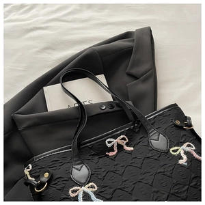Détail du sac cabas plissé noir avec broderie de nœuds colorés et tissu texturé