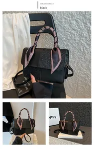 Detail of black leather and sequin crossbody bag with decorative plaid handle scarf