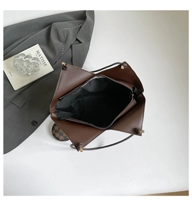 Detailed top view of brown leather bucket bag with geometric folds and checkered interior
