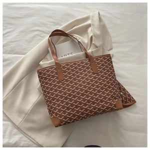 Detail shot of brown monogram tote bag with leather straps on white aesthetic background