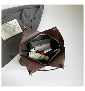 Vista dall'alto dell'interno della borsa tote marrone con tablet, ombrello e trucchi