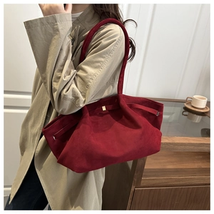 Detail of the adjustable metal buckle and burgundy suede texture on this shoulder bag