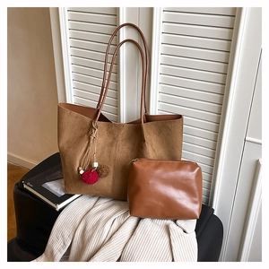 Detail of a large brown suede tote bag and matching leather pouch for daily commuting