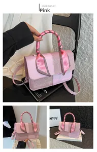 Detail of pink crossbody bag with satin ribbon handle and glossy texture contrast