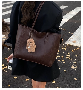 Détail du cabas marron foncé avec texture cuir et breloque ours en peluche