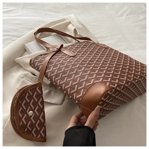 Detail of printed tote bag and small pouch on white blazer with leather strap handle
