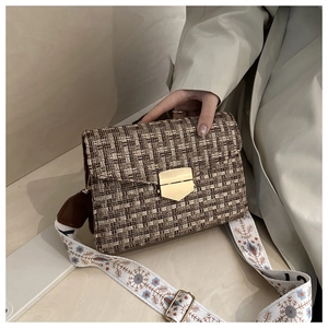 Détail du sac en tweed avec fermoir doré et bandoulière brodée de fleurs colorées