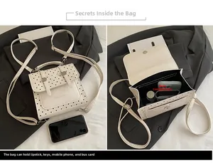 Detail view of mini polka dot backpack interior showing storage for phone and makeup