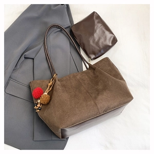 Détail du grand sac cabas marron en daim avec anses en cuir et pompon décoratif