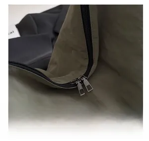 Detail of smooth metal double zippers on army green nylon tote bag for women