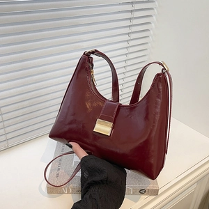 Minimalist wine red glossy patent leather hobo bag with gold buckle and shoulder strap