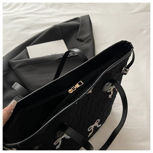 Détail du sac cabas matelassé noir avec nœuds brodés colorés et fermeture à glissière