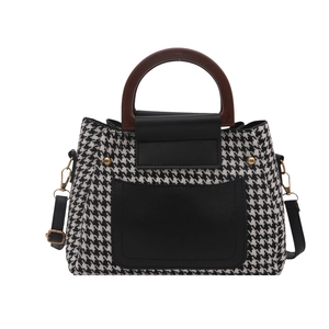 Classic houndstooth handbag with black leather panels and brown circular handle
