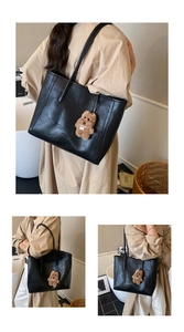 Détail du sac cabas en cuir noir avec lettrage tendance et pendentif ours en peluche