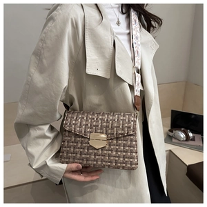 Détail d'un sac bandoulière en tweed vintage avec boucle dorée et sangle brodée