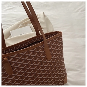 Macro shot of brown Y-pattern tote bag detailing leather stitching and texture