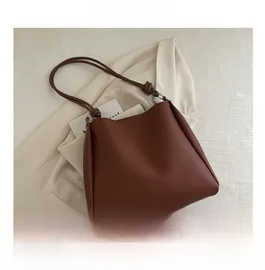Brown faux leather tote bag detail with knot shoulder strap and size reference