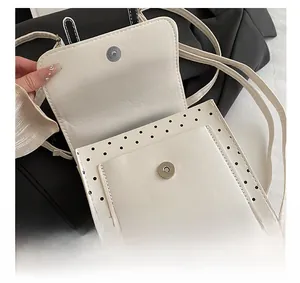 Detail view of the black polka dot white leather bag interior with magnetic metal closure